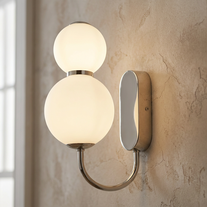 Snowball 2 wall light in chrome with two glowing opal glass globes on a textured wall.
