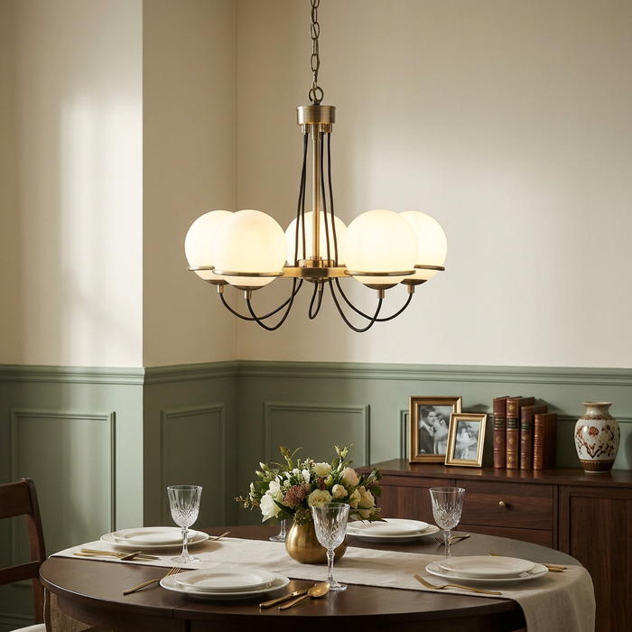Sphere 5 light brass and braided cable pendant with white opal shades above a set dining table.