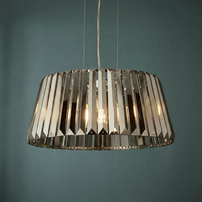Illuminated Tiara 5-light pendant with smoke chrome glass crystals against a dark teal wall.