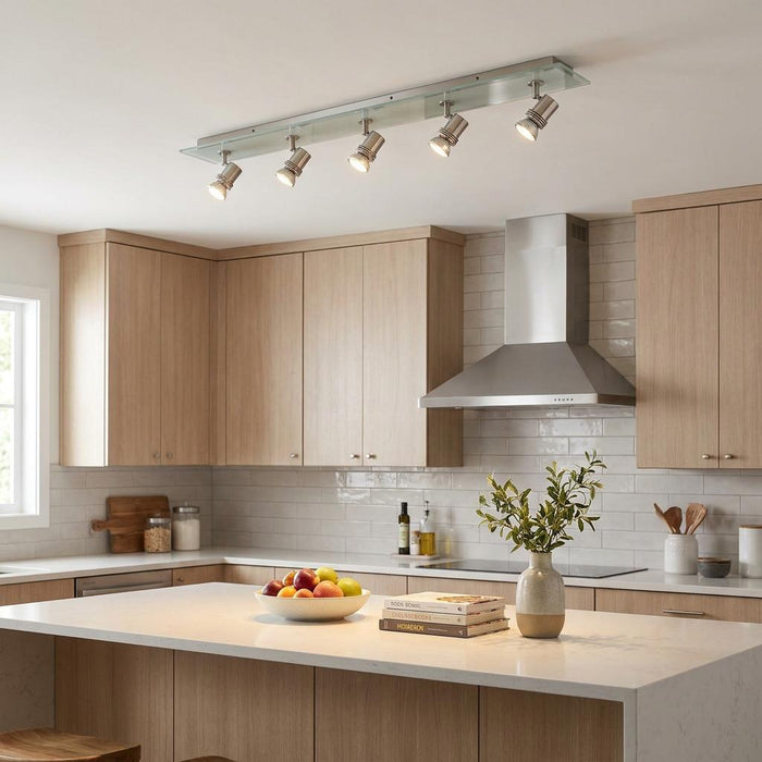 Top Hat 5 Light Bar silver adjustable spotlights on a ceiling over a kitchen island with light wood cabinetry.