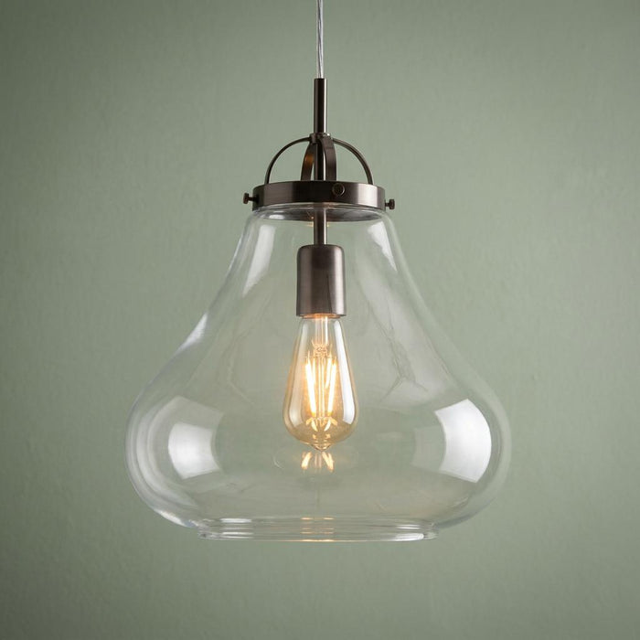Antique chrome ceiling lantern with a clear glass teardrop shade and Edison bulb against a sage green wall.