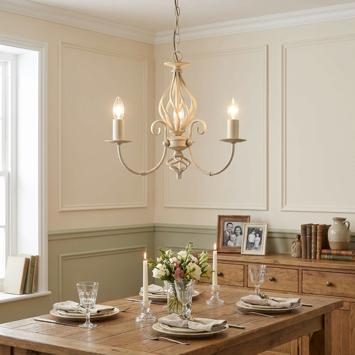 Tuscany ivory finish 3-light chandelier with scrolled arms hanging above a rustic wooden dining table.