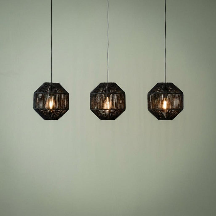 Three black rope effect pendant lights with glowing bulbs against a light green wall.